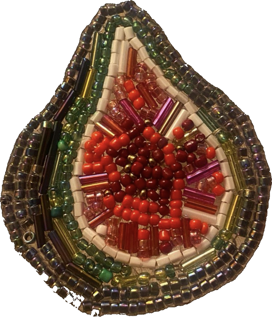 A hand-beaded fig, sliced open to show its red seedy centre